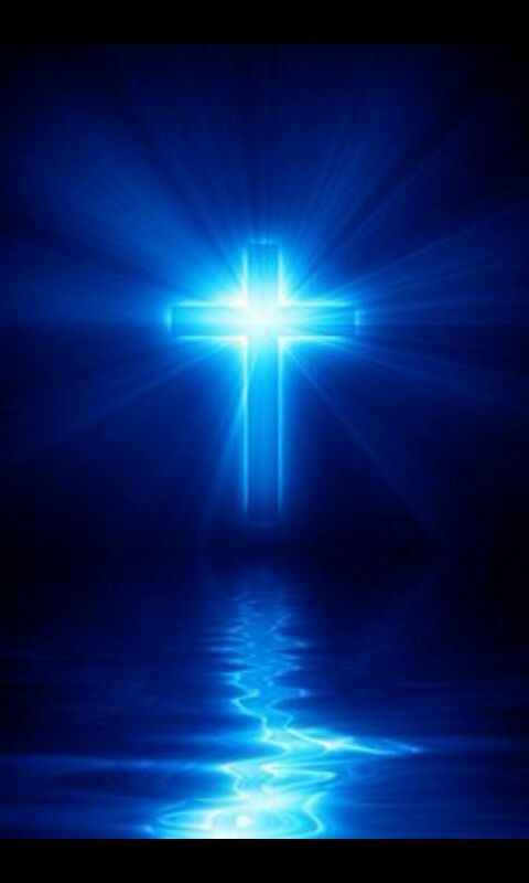 A blue lighted cross hovering over water